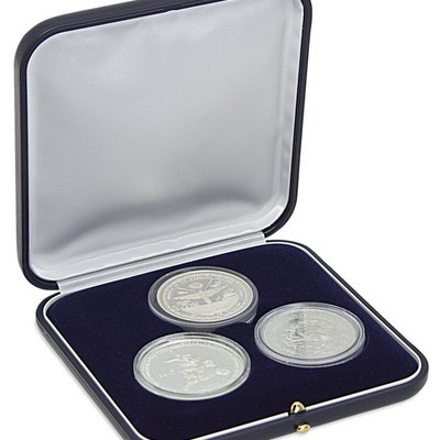 Estuche con insertos de terciopelo azul para guardar tres monedas